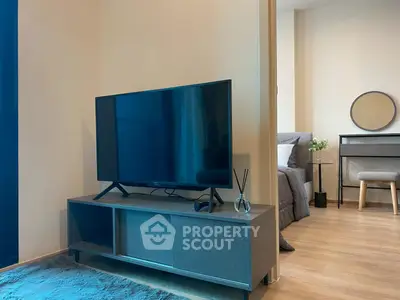 Modern living room with sleek TV setup and cozy bedroom view