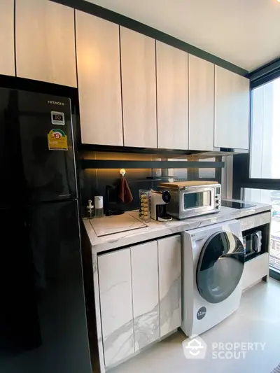 Modern kitchen with sleek appliances and large window view