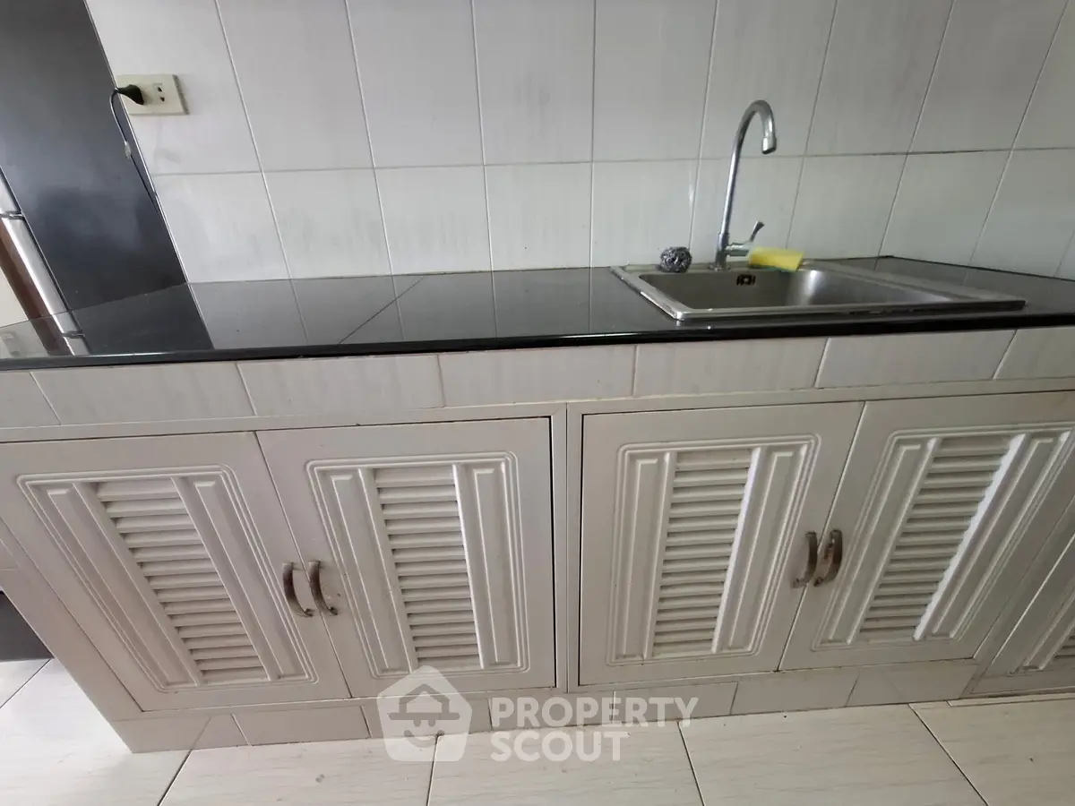 Modern kitchen with sleek cabinetry and stainless steel sink, perfect for culinary enthusiasts.