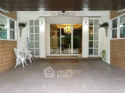 Elegant entrance with glass doors and stylish outdoor seating