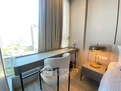 Modern bedroom with city view, featuring sleek desk and stylish lamp, perfect for urban living.