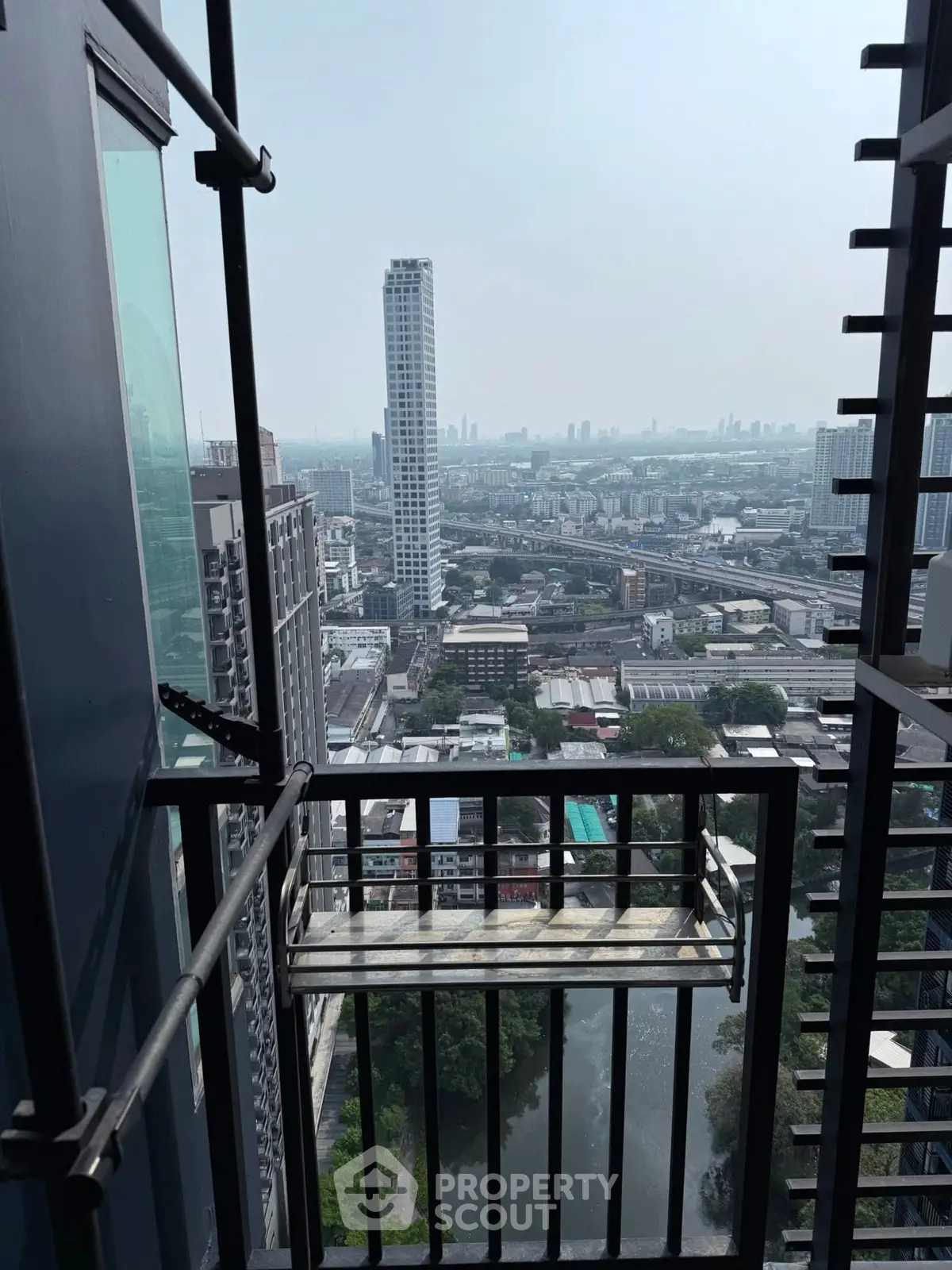 Stunning high-rise balcony view overlooking city skyline and river, perfect for urban living.