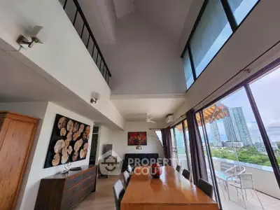 Stunning high-ceiling living room with panoramic city views and elegant dining area.