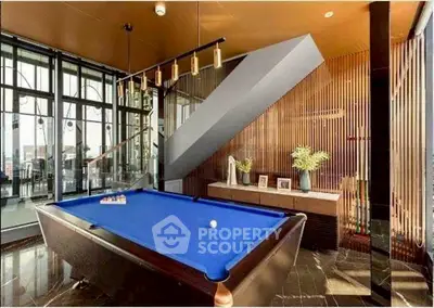 Luxurious modern living room with pool table and stunning city view.
