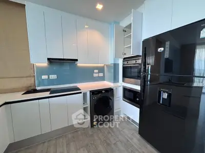 Modern kitchen with sleek appliances and stylish cabinetry in a contemporary apartment.