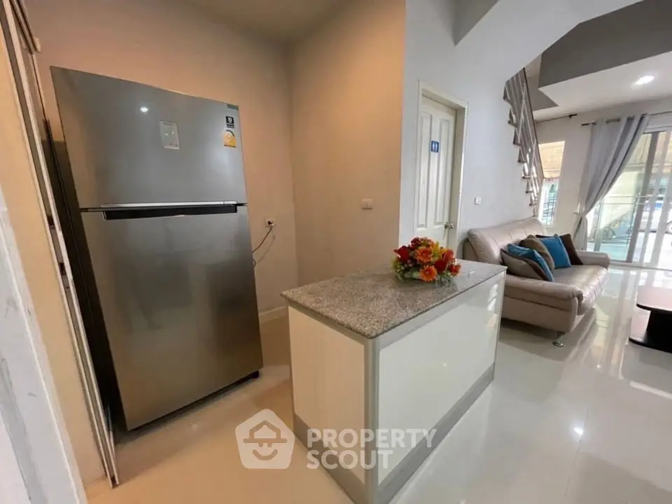 Modern living room with sleek kitchen island and stainless steel fridge
