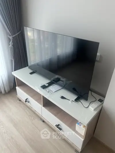 Modern living room with sleek TV setup and stylish curtains