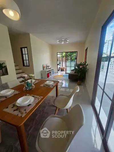 Stylish open-plan dining and living area with modern decor and natural light.