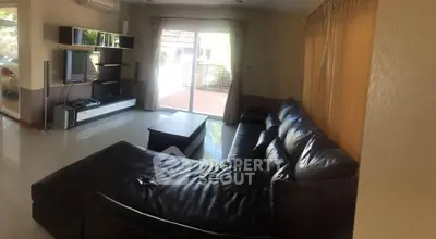 Spacious living room with modern leather sofa and entertainment center