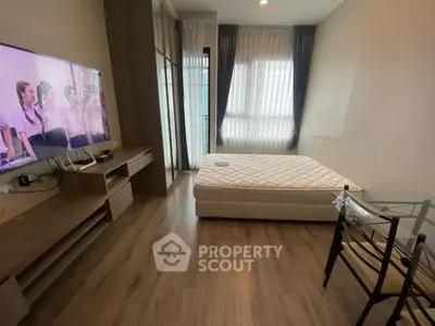 Modern bedroom with sleek wooden flooring, large window, and wall-mounted TV for a cozy living experience.
