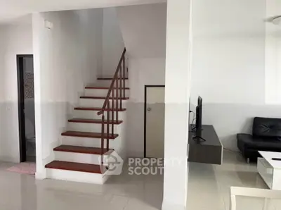 Modern interior with sleek staircase and cozy living area, perfect for stylish urban living.