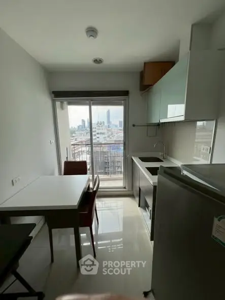 Modern kitchen with city view, sleek appliances, and dining area in a compact space.