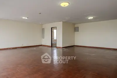 Spacious empty room with wooden flooring and neutral walls, ideal for customization.