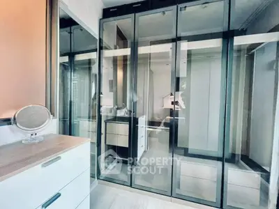 Modern bedroom with sleek glass wardrobe and stylish dresser