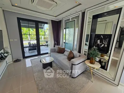 Luxurious living room with modern decor and large windows overlooking greenery
