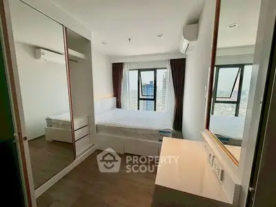 Modern bedroom with city view, mirrored wardrobe, and sleek design in high-rise apartment.