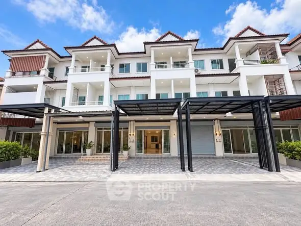 Stunning multi-story building with modern architecture and spacious balconies under a clear blue sky.