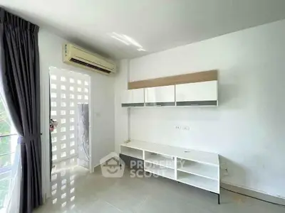 Modern living room with sleek white furniture and air conditioning, perfect for comfortable living.
