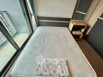 Spacious bedroom with large windows and balcony access, featuring a comfortable bed and modern furnishings.