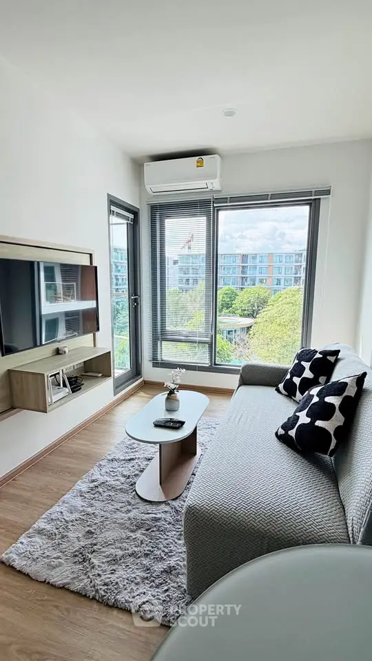 Modern living room with stylish decor and large windows offering a scenic view.