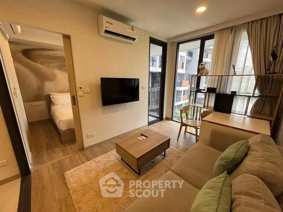 Modern living room with cozy sofa, wall-mounted TV, and balcony view in stylish apartment.