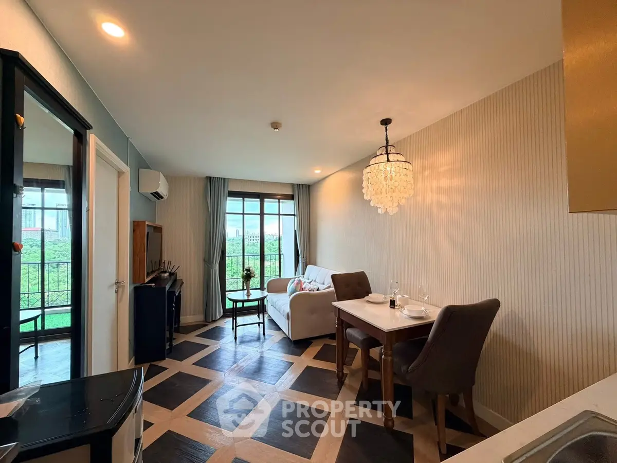 Stylish living room with elegant chandelier and large windows offering a scenic view, perfect for modern living.