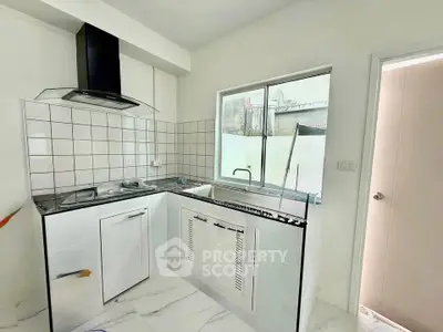 Modern kitchen with sleek design, featuring a gas stove and ample natural light.