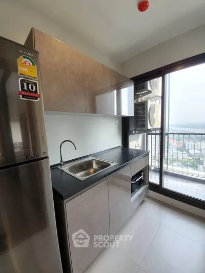 Modern kitchen with sleek cabinetry and stainless steel appliances, featuring a large window with a stunning view.