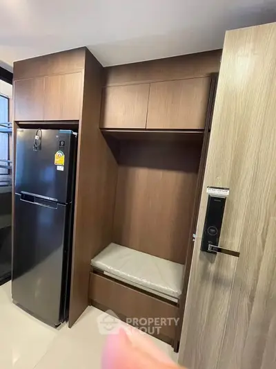 Modern kitchen with sleek wooden cabinetry and stainless steel refrigerator