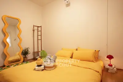 Cozy bedroom with vibrant yellow bedding and unique mirror design