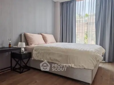 Modern bedroom with elegant decor and large window offering natural light.