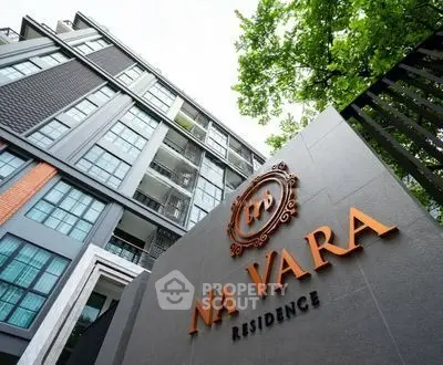 Modern building exterior of Na Vara Residence with lush greenery and sleek architectural design.