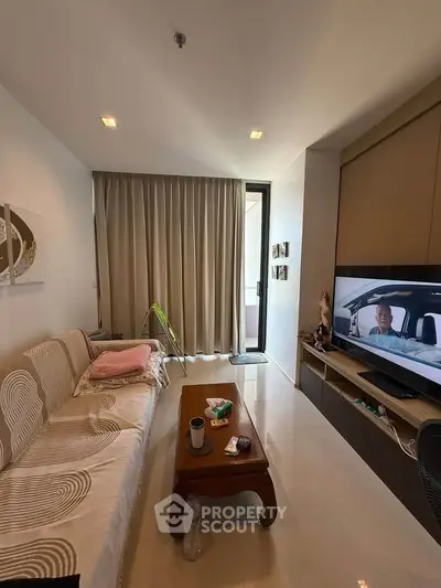 Cozy living room with modern decor and TV, perfect for relaxation.