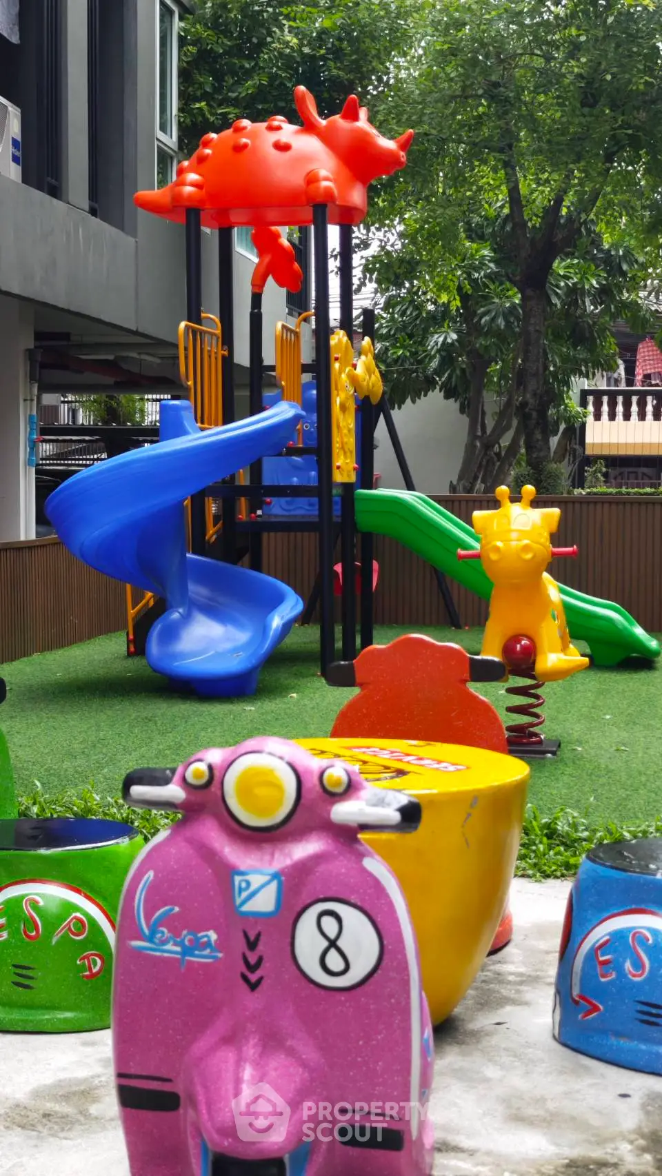 Vibrant children's playground with colorful slides and animal-themed rides in a residential complex.
