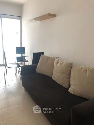 Cozy living room with modern sofa and dining table, perfect for urban living.