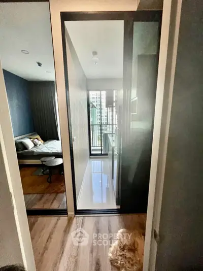 Modern apartment hallway leading to a cozy bedroom with city view.