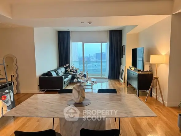 Spacious modern living room with city view, elegant decor, and natural light.