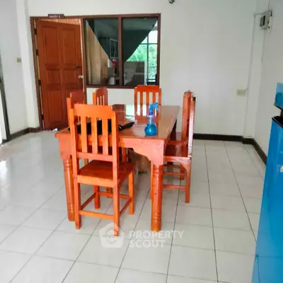 Spacious dining area with wooden table and chairs, perfect for family gatherings.