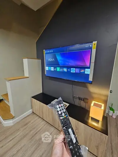 Modern living room with wall-mounted TV and stylish wooden cabinet