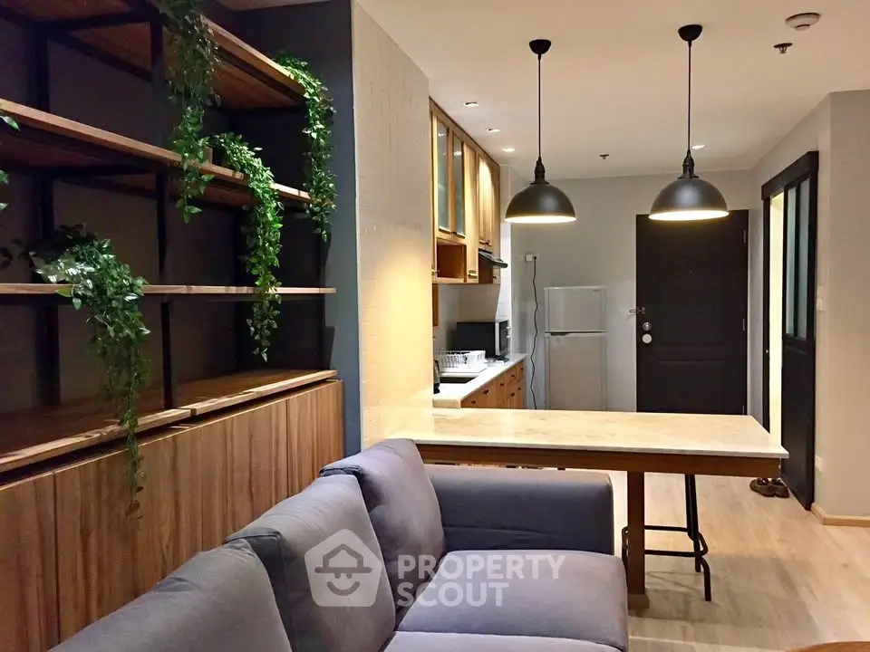 Modern open-layout living room with stylish kitchen and cozy sofa, perfect for urban living.