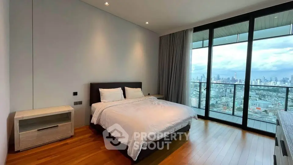 Luxurious bedroom with stunning city view and floor-to-ceiling windows in modern apartment.