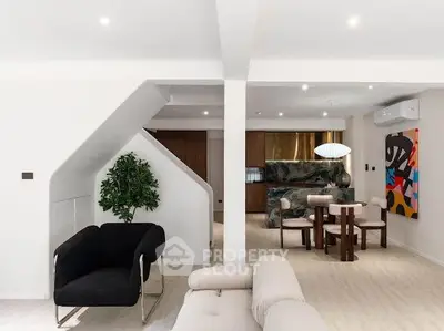 Modern open-plan living room with stylish furniture and contemporary art