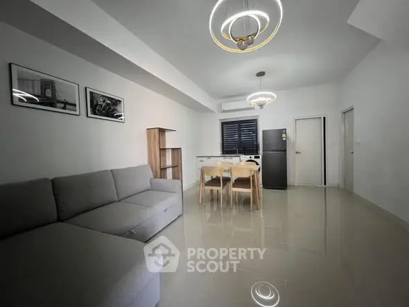 Modern living room with sleek furniture and stylish lighting fixtures.