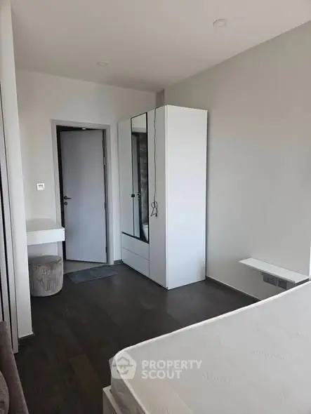 Modern minimalist bedroom with sleek furniture and neutral tones.