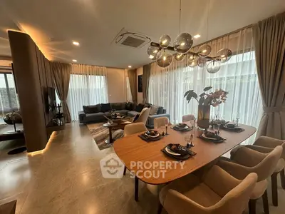 Luxurious open-plan living and dining area with modern decor and elegant lighting.