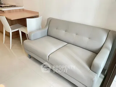 Modern living room with sleek gray sofa and compact dining area, perfect for urban living.
