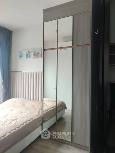 Modern bedroom with mirrored wardrobe and cozy bed in stylish apartment.