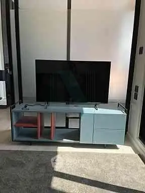 Modern living room with sleek TV stand and large flat-screen TV, perfect for entertainment.