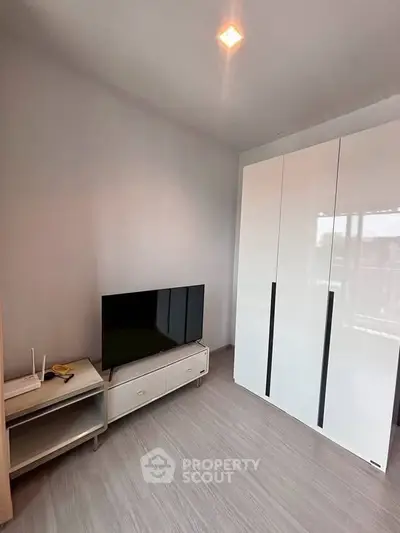 Modern bedroom with sleek wardrobe and flat-screen TV