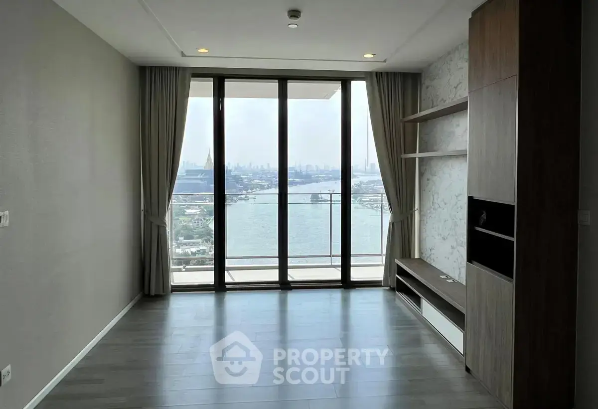 Spacious living room with floor-to-ceiling windows offering stunning river views.
